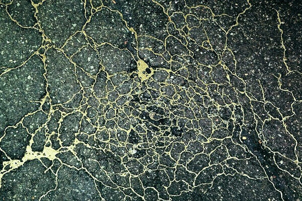 В Киеве на трещины в асфальте художник наносит золотую пудру (фото, видео)